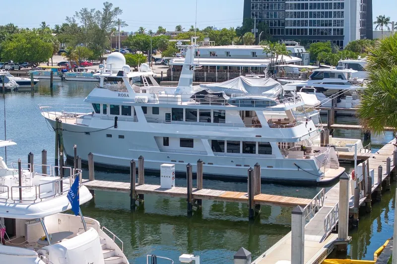 The Image of Luxury yacht ABD 90 Explorer 1996 docked at marina, surrounded by other boats and lush greenery. - 0