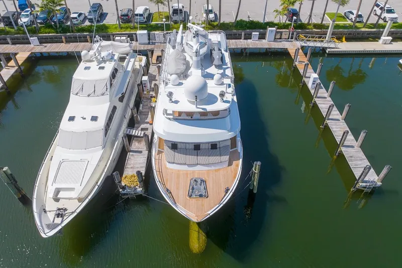 Slide: The Image of Two luxury yachts docked at a marina, featuring the 1996 ABD 90 Explorer. - 16