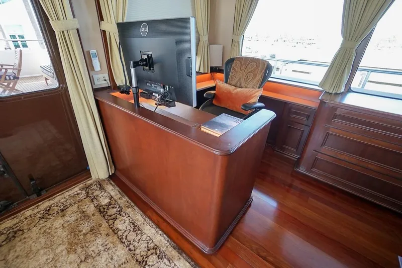 Slide: The Image of Luxurious yacht interior with wooden desk, monitor, and elegant chair, featuring large windows and curtains. - 56
