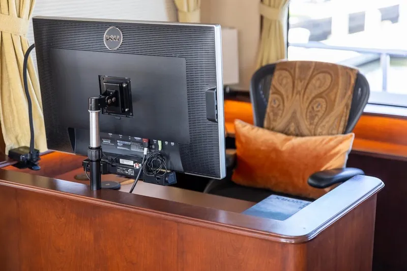 Slide: The Image of Office setup with Dell monitor, ergonomic chair, and orange cushion on a wooden desk. - 74