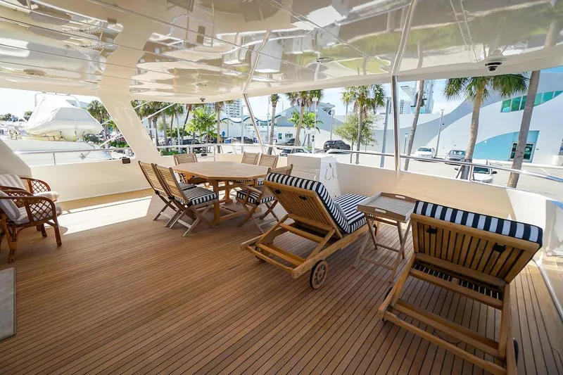 Slide: The Image of Luxurious deck of 1996 ABD 90 Explorer yacht with wooden furniture and striped cushions. - 78