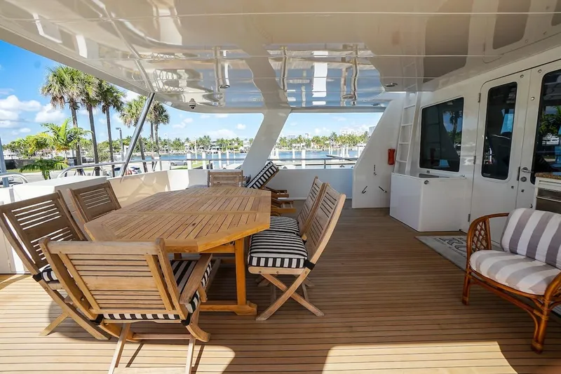 Slide: The Image of Luxurious deck of 1996 ABD 90 Explorer yacht with wooden furniture and scenic marina view. - 79