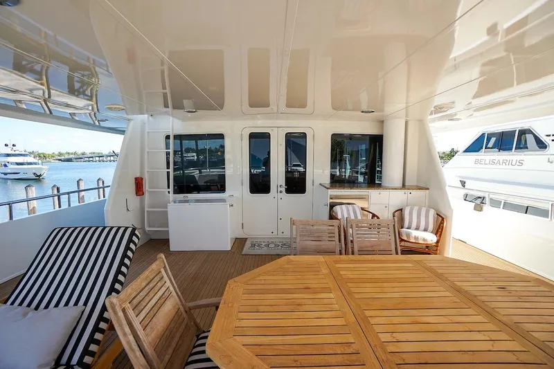 Slide: The Image of Spacious deck of 1996 ABD 90 Explorer yacht with wooden furniture and scenic marina view. - 80