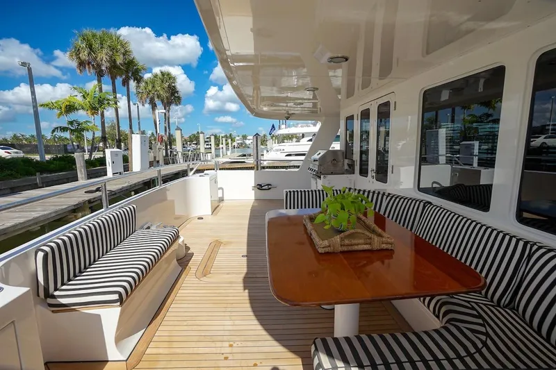 Slide: The Image of Luxurious 1996 ABD 90 Explorer yacht deck with striped seating and wooden table. - 96