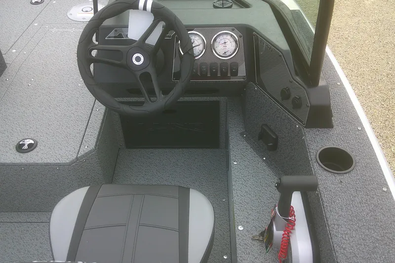 Slide: The Image of 2026 Lund 1800 Explorer Sport boat interior with steering wheel and dashboard controls. - 10