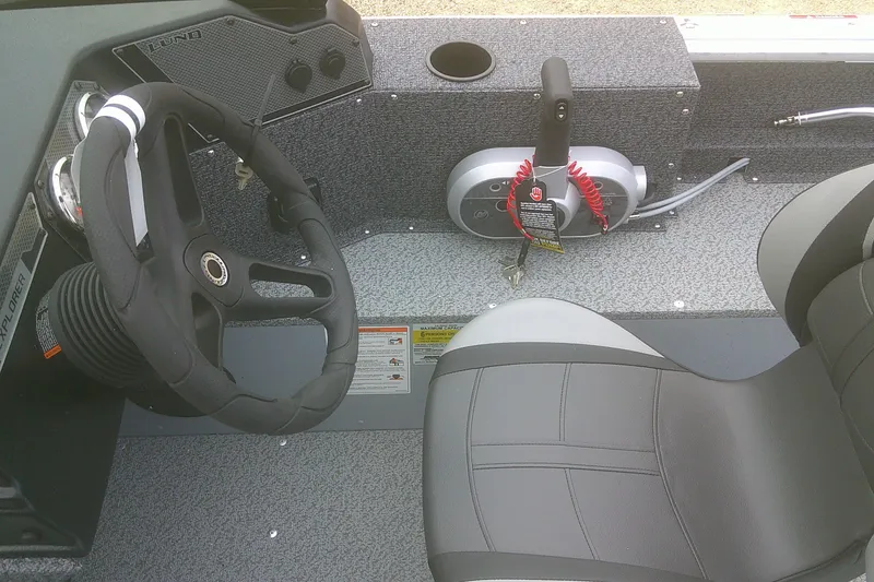 Slide: The Image of 2026 Lund 1800 Explorer Sport boat interior with steering wheel and control panel. - 12
