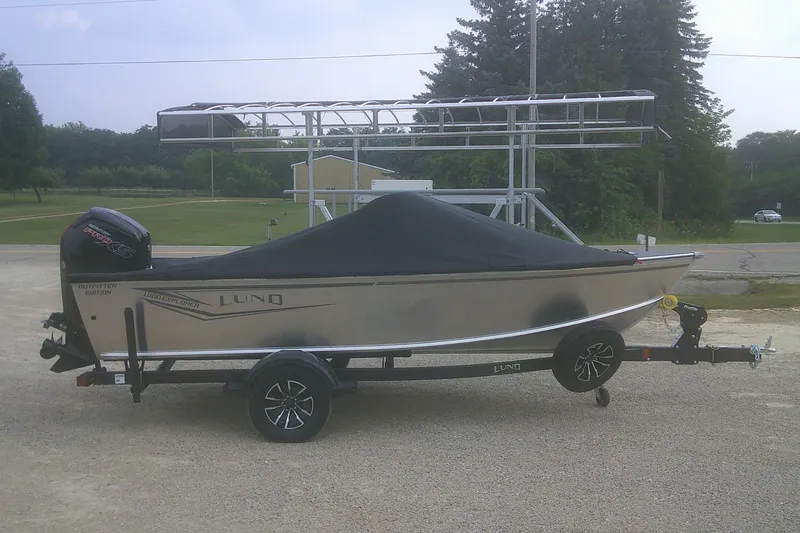 Slide: The Image of 2026 Lund 1800 Explorer Sport boat on trailer, covered, parked outdoors. - 16