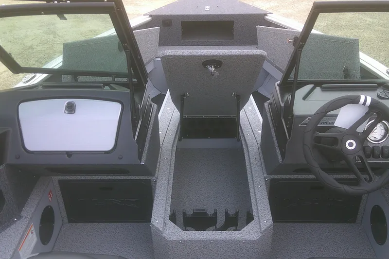 Slide: The Image of 2026 Lund 1800 Explorer Sport boat interior with open storage compartments and steering wheel. - 7