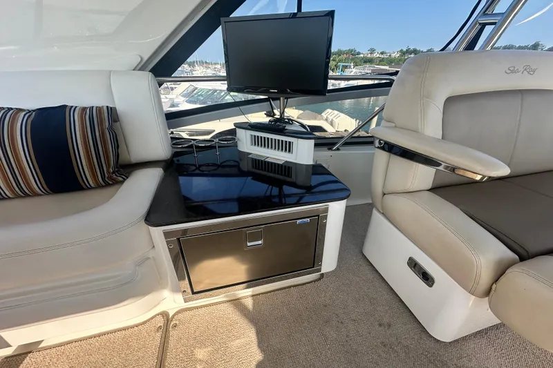 Slide: The Image of Interior of 2014 Sea Ray 450 Sedan Bridge with seating, TV, and mini-fridge. - 17