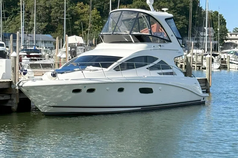 Slide: The Image of 2014 Sea Ray 450 Sedan Bridge yacht docked in a marina. - 2