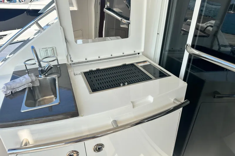 Slide: The Image of Outdoor kitchen area on 2014 Sea Ray 450 Sedan Bridge yacht with sink and grill. - 25