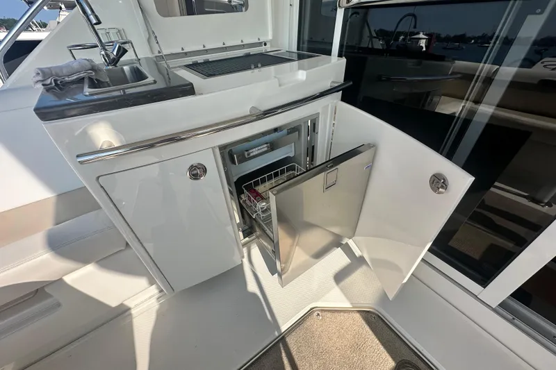 Slide: The Image of 2014 Sea Ray 450 Sedan Bridge yacht kitchenette with open fridge and sink. - 26