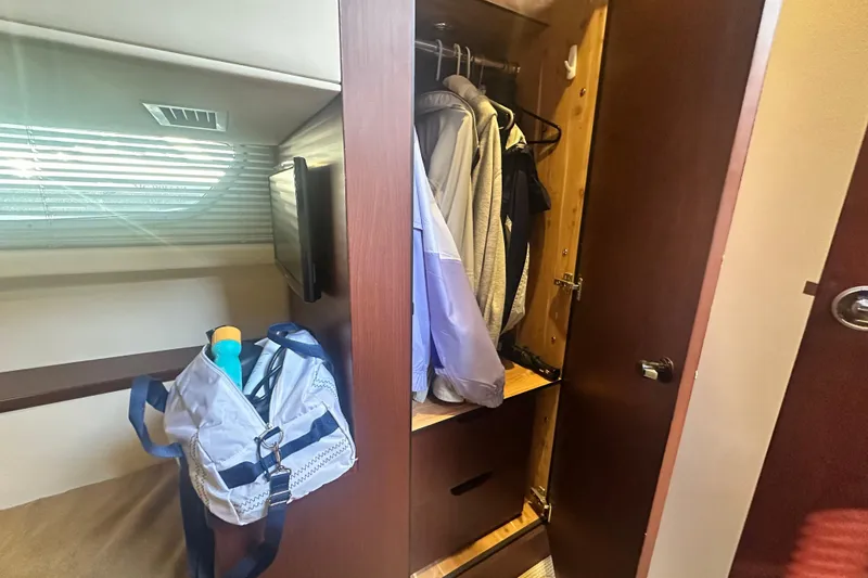 Slide: The Image of Interior of 2014 Sea Ray 450 Sedan Bridge showing closet and duffel bag. - 38