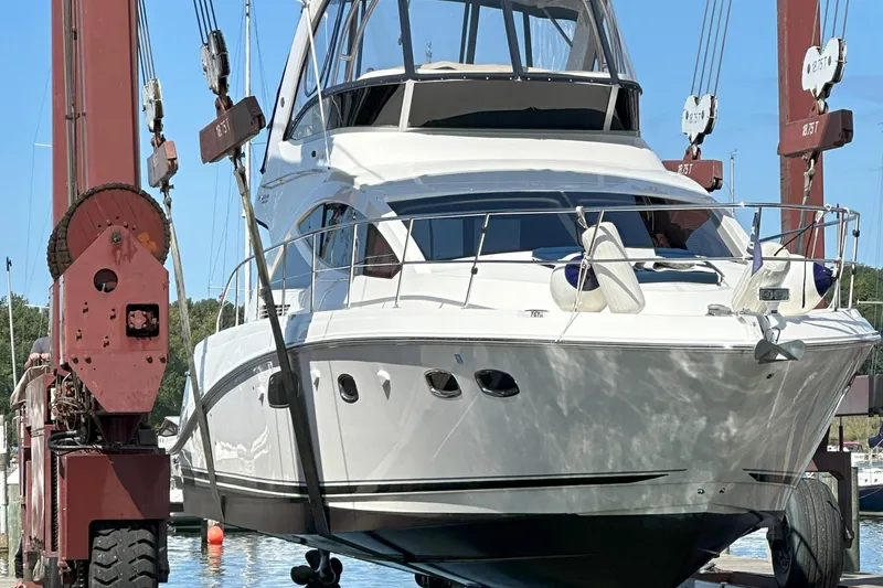 Slide: The Image of 2014 Sea Ray 450 Sedan Bridge yacht being lifted by a crane at a marina. - 4
