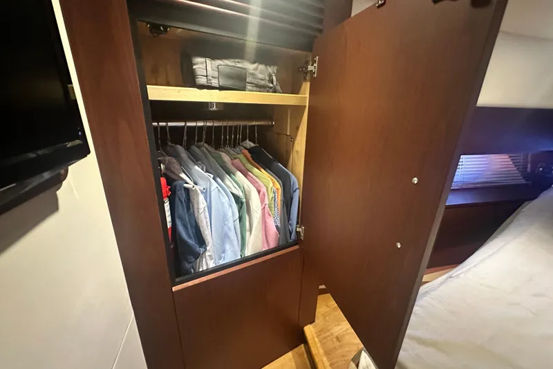 Slide: The Image of Closet with hanging clothes inside a 2014 Sea Ray 450 Sedan Bridge yacht. - 52