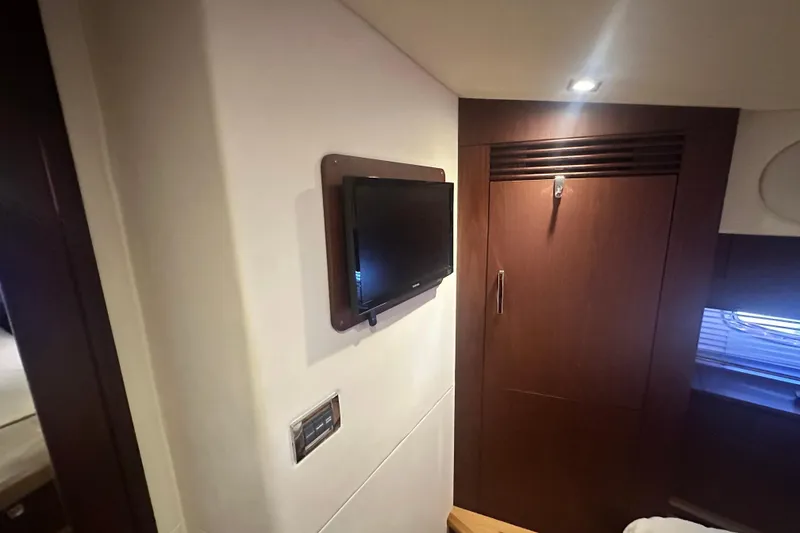 Slide: The Image of Interior of 2014 Sea Ray 450 Sedan Bridge with wall-mounted TV and wooden cabinetry. - 53
