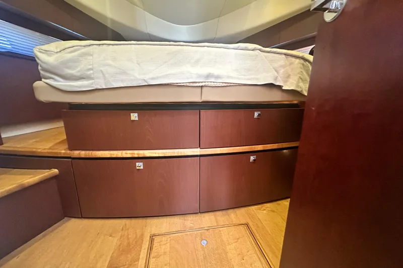Slide: The Image of Interior of 2014 Sea Ray 450 Sedan Bridge with wooden storage drawers under bed. - 54