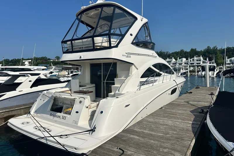 Slide: The Image of 2014 Sea Ray 450 Sedan Bridge yacht docked at marina, clear blue sky. - 6