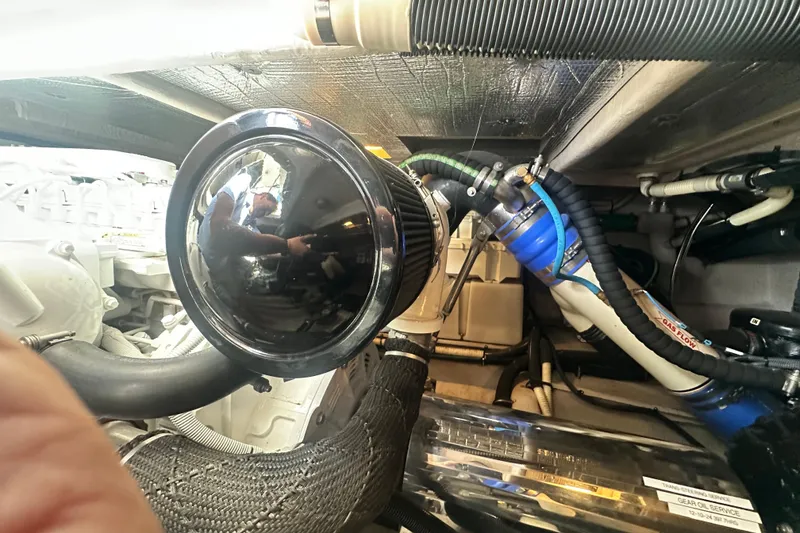 Slide: The Image of Engine room of a 2014 Sea Ray 450 Sedan Bridge with visible components and hoses. - 67