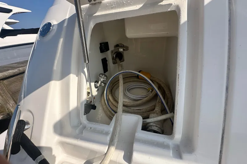 Slide: The Image of 2014 Sea Ray 450 Sedan Bridge storage compartment with coiled hoses and fittings. - 72
