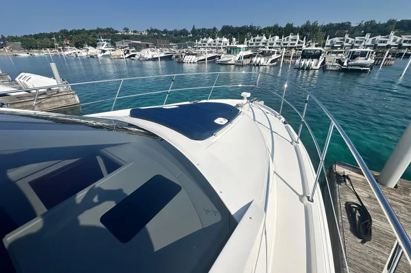 Slide: The Image of 2014 Sea Ray 450 Sedan Bridge yacht docked at a marina with clear blue water. - 73