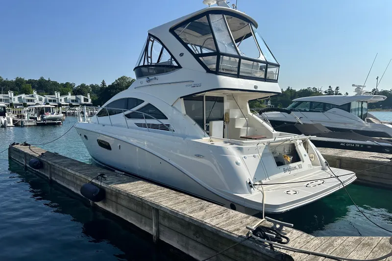 Slide: The Image of 2014 Sea Ray 450 Sedan Bridge yacht docked at marina, sunny day. - 8
