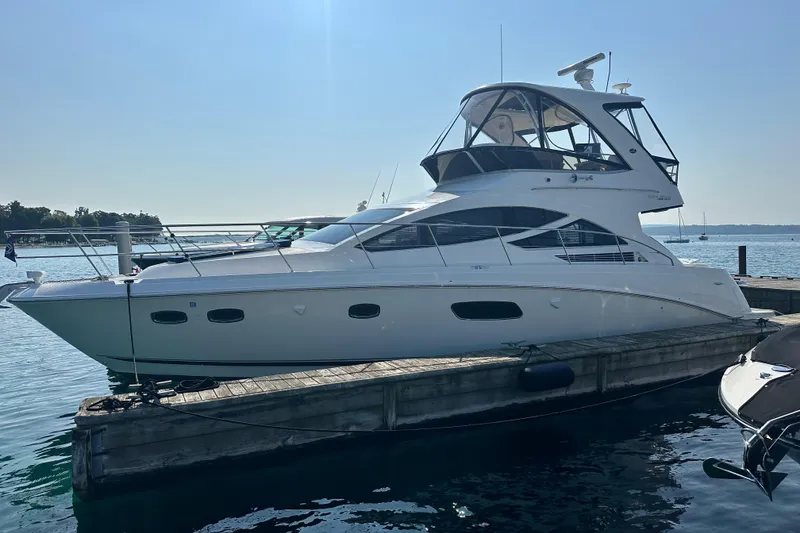 Slide: The Image of 2014 Sea Ray 450 Sedan Bridge yacht docked at marina under clear sky. - 9