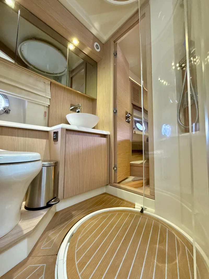 Slide: The Image of Luxurious bathroom in 2017 Beneteau Monte Carlo 5S yacht with modern fixtures and wood accents. - 14