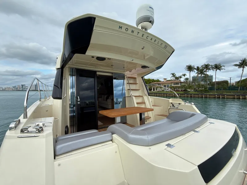 Slide: The Image of 2017 Beneteau Monte Carlo 5S yacht, rear view, docked by palm trees and water. - 22