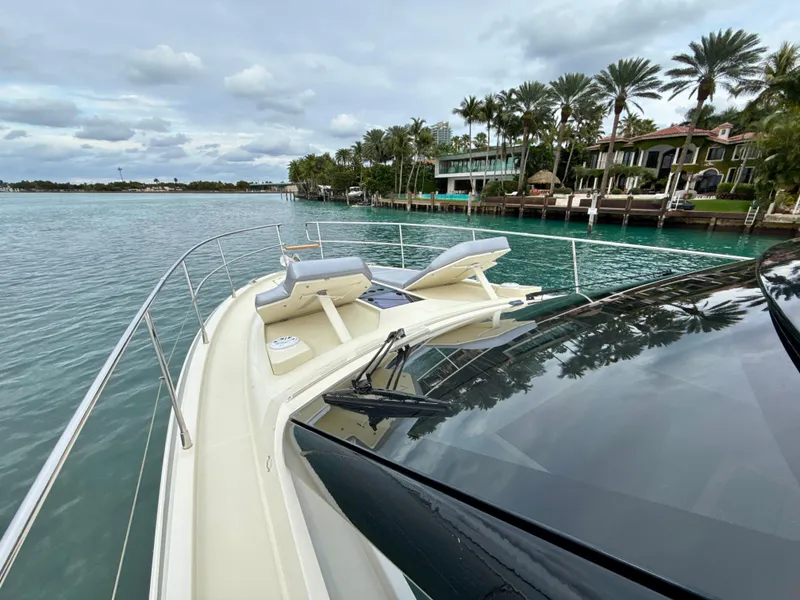 Slide: The Image of 2017 Beneteau Monte Carlo 5S yacht cruising near waterfront homes and palm trees. - 28