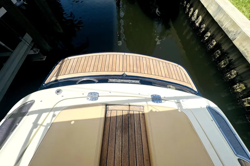 Slide: The Image of 2013 Chris-Craft Corsair 22 boat with teak deck, docked in calm water. - 13