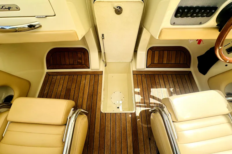 Slide: The Image of 2013 Chris-Craft Corsair 22 interior with teak flooring and beige leather seats. - 14