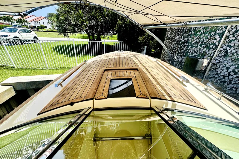 Slide: The Image of 2013 Chris-Craft Corsair 22 boat with wooden deck, parked under a canopy. - 15