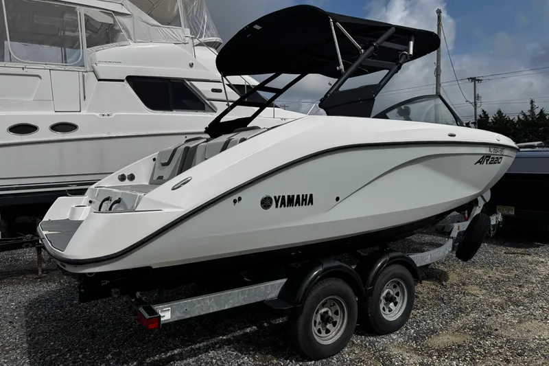 Slide: The Image of 2023 Yamaha Boats AR220 on trailer, sleek design, parked outdoors. - 4