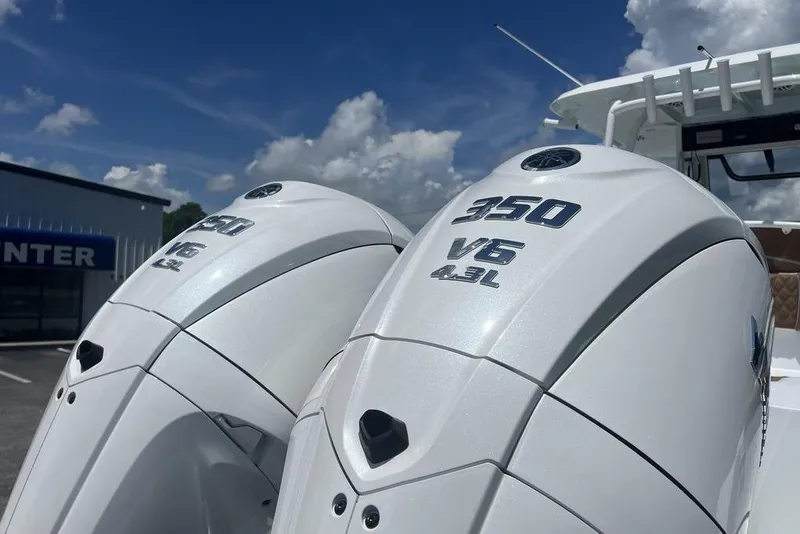 Slide: The Image of Twin 350 V6 outboard engines on 2026 Sea Hunt Gamefish 30 boat under blue sky. - 12