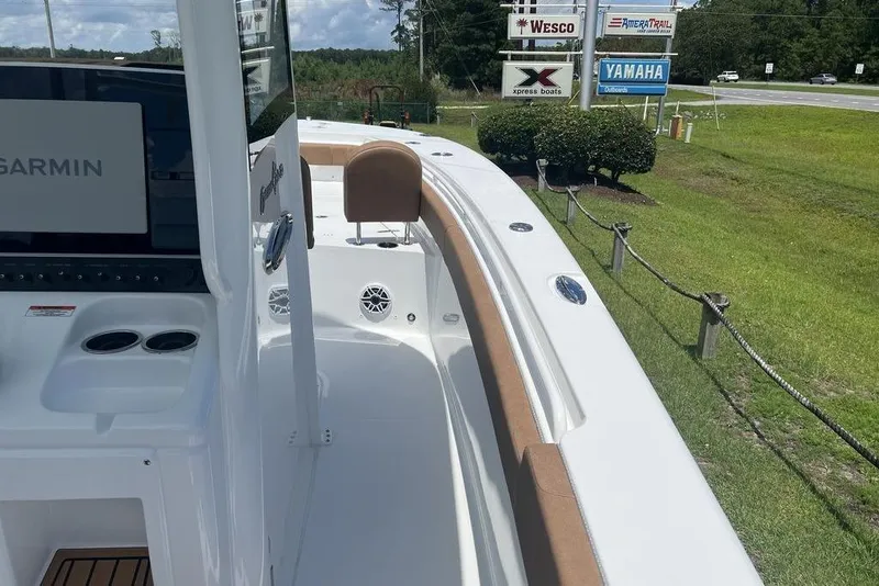 Slide: The Image of 2026 Sea Hunt Gamefish 30 boat with forward seating, Garmin display, and lush green surroundings. - 16