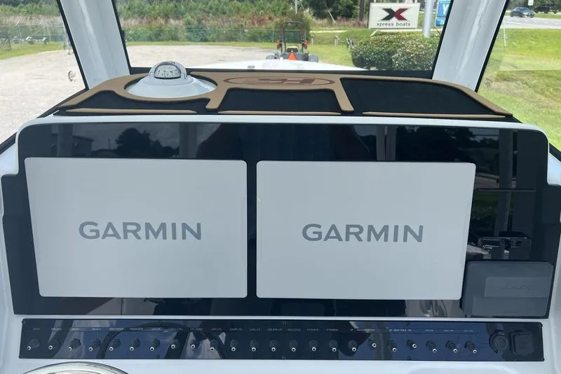 Slide: The Image of 2026 Sea Hunt Gamefish 30 dashboard with dual Garmin displays and compass. - 17