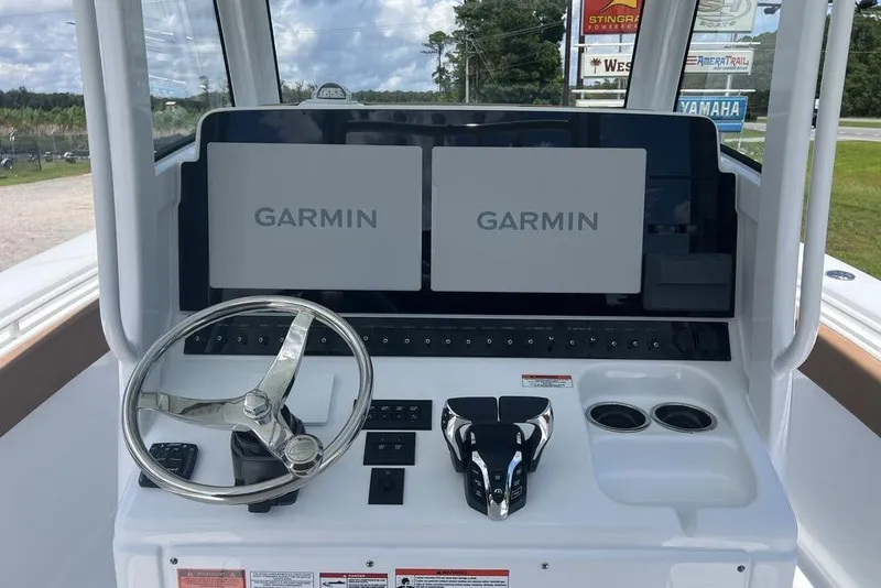 Slide: The Image of 2026 Sea Hunt Gamefish 30 helm with dual Garmin displays and stainless steel steering wheel. - 18