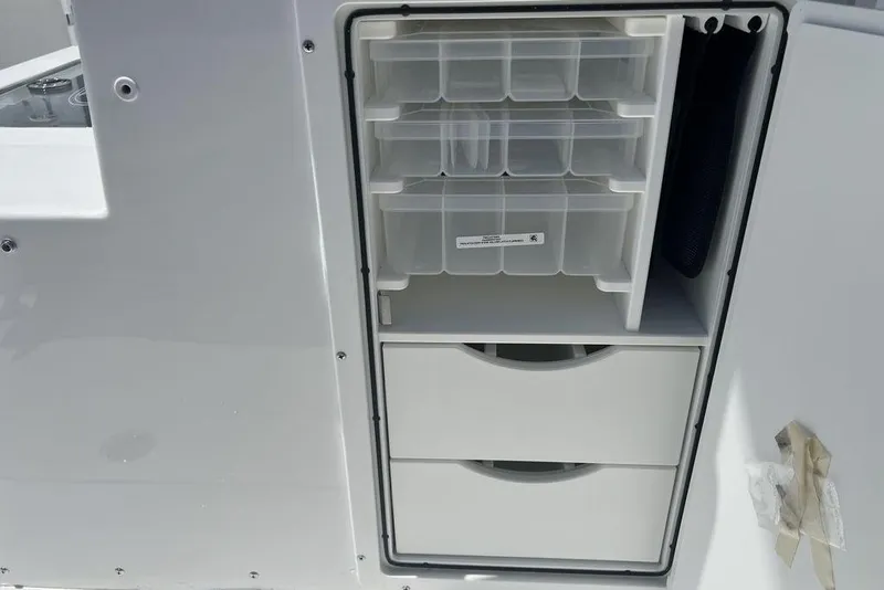 Slide: The Image of 2026 Sea Hunt Gamefish 30 storage compartment with organized tackle boxes and drawers. - 36