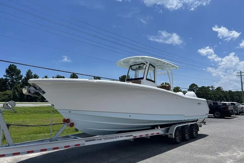 Slide: The Image of 2026 Sea Hunt Gamefish 30 Forward Seating boat on trailer under clear blue sky. - 5