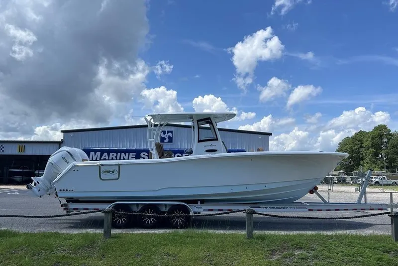 Slide: The Image of 2026 Sea Hunt Gamefish 30 boat on trailer, parked outside marine storage facility. - 6
