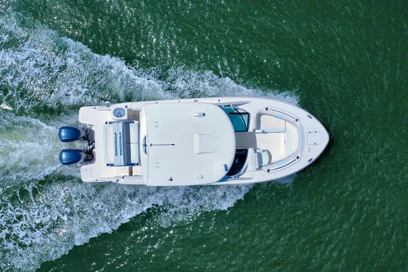 Slide: The Image of Overhead view of 2019 Robalo R317 Dual Console boat cruising on water. - 15