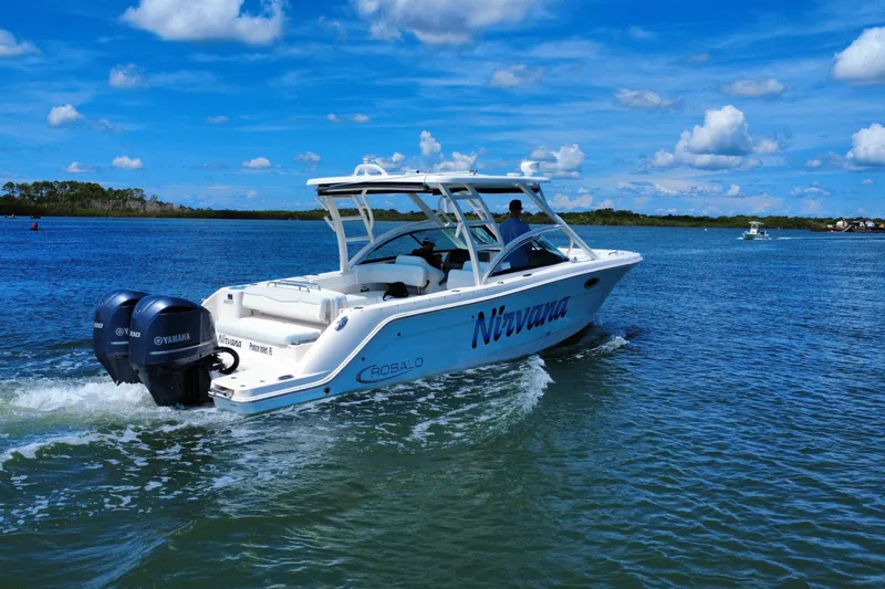 Slide: The Image of 2019 Robalo R317 Dual Console boat cruising on a sunny day with Yamaha engines. - 18