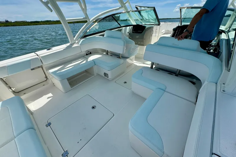 Slide: The Image of 2019 Robalo R317 Dual Console boat interior with white seating and open water view. - 2