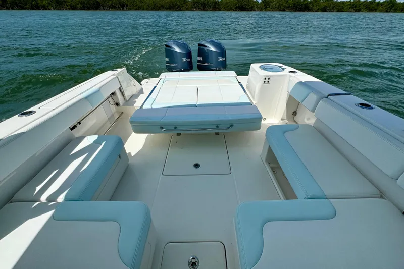 Slide: The Image of 2019 Robalo R317 Dual Console boat interior with seating and twin engines on water. - 23