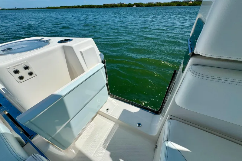 Slide: The Image of 2019 Robalo R317 Dual Console boat with open side door, overlooking calm water. - 25