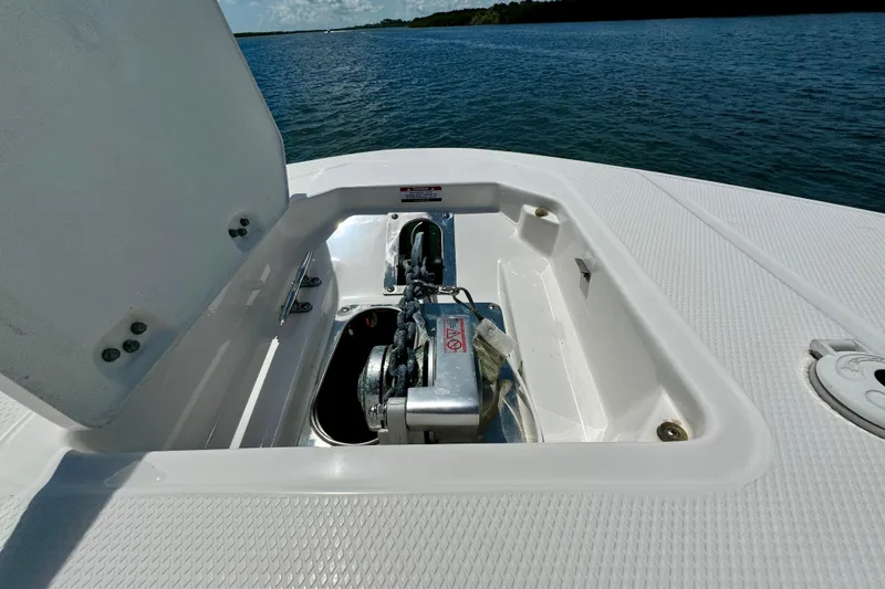 Slide: The Image of 2019 Robalo R317 Dual Console boat anchor compartment on open water. - 28