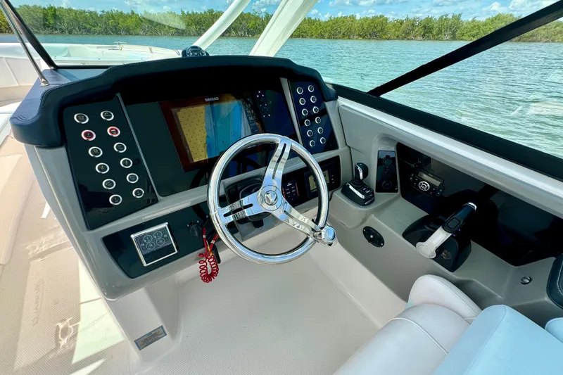 Slide: The Image of 2019 Robalo R317 Dual Console boat dashboard with steering wheel and control panel. - 33