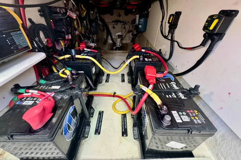 Slide: The Image of 2019 Robalo R317 Dual Console boat battery compartment with multiple connected batteries. - 45