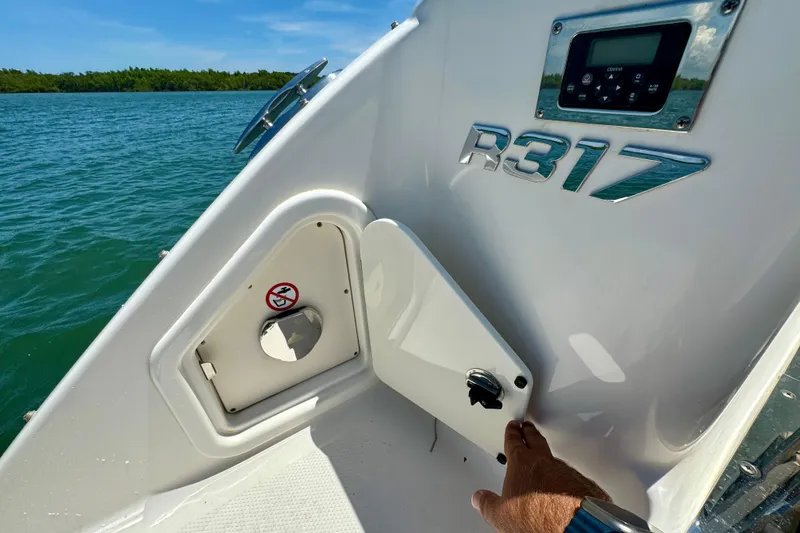 Slide: The Image of 2019 Robalo R317 Dual Console boat detail with control panel and storage compartment. - 51